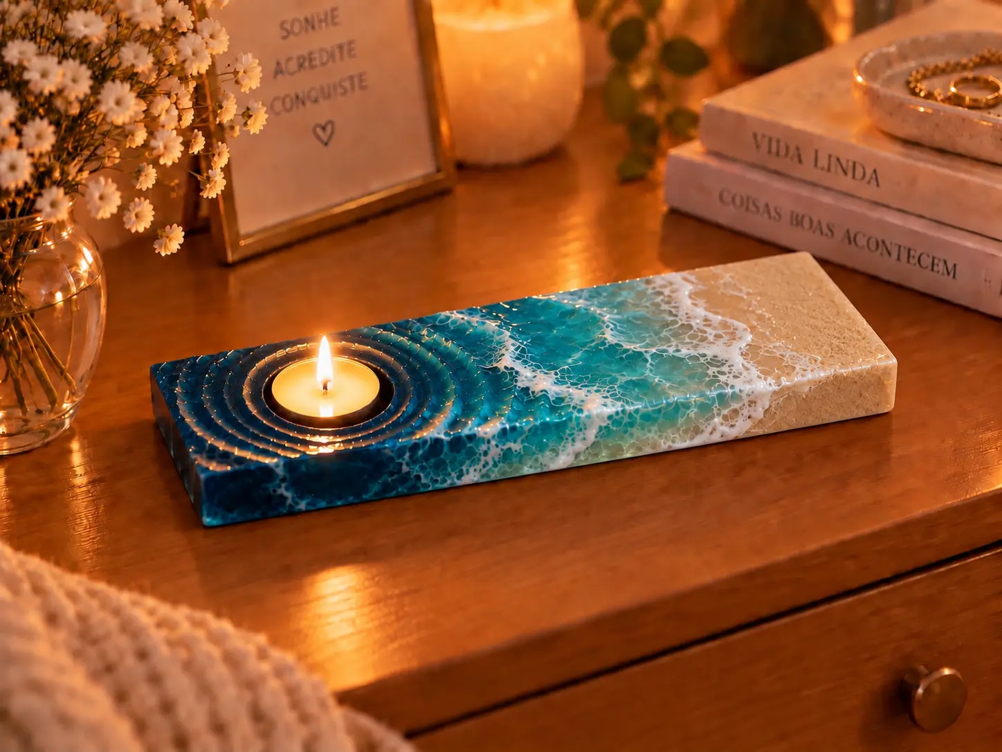 Peça decorativa com vela e acabamento que evoca o encontro do mar com a areia