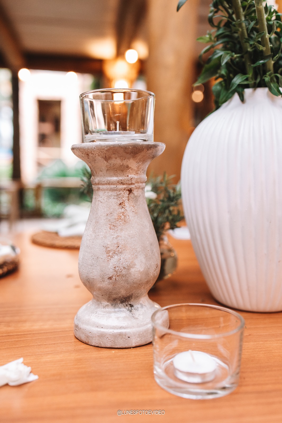 Castiçal de textura mineral em uma mesa, com vela acesa